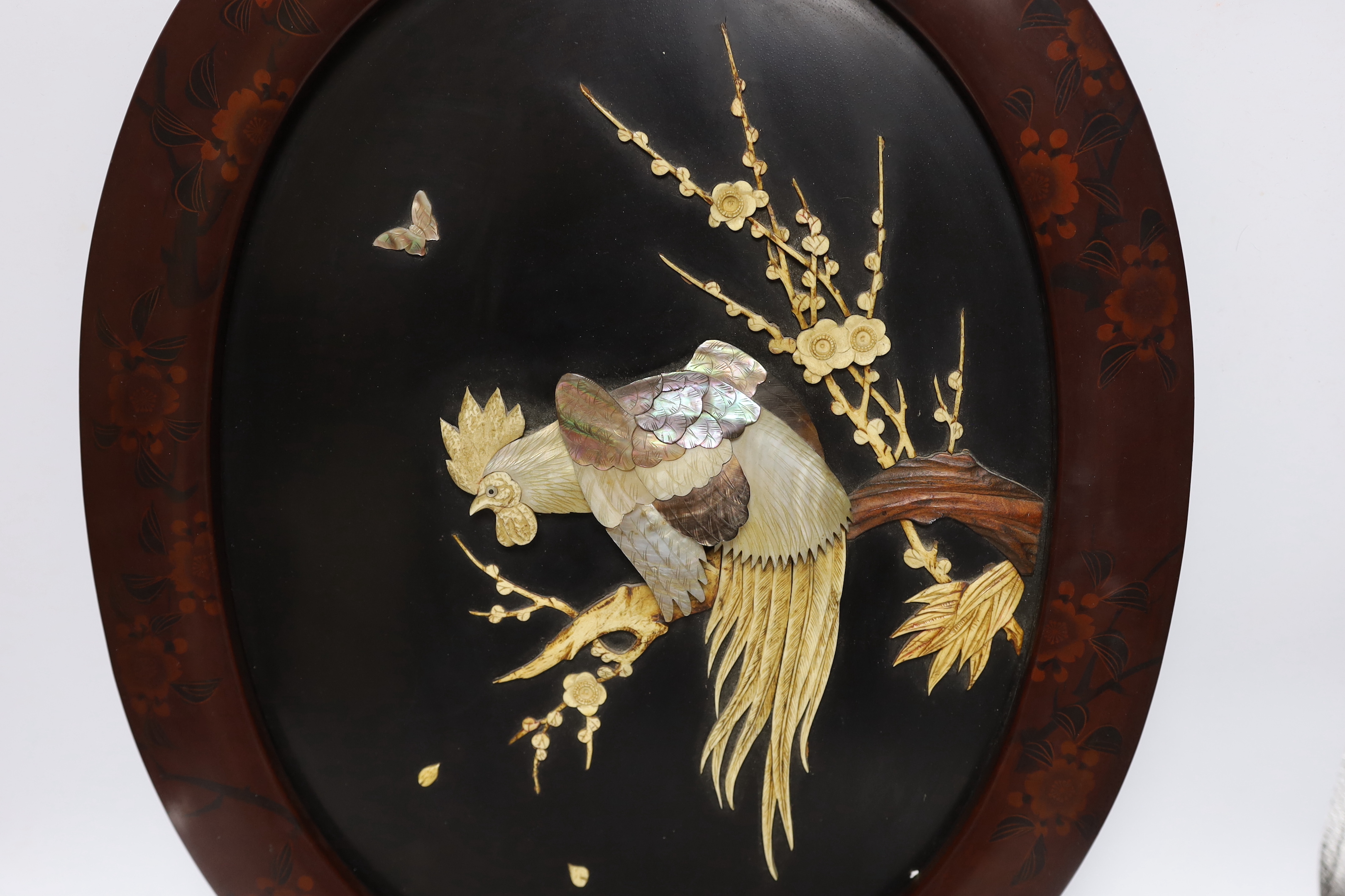 A Japanese bone and mother of pearl inlaid oval panel, cockerel amongst flowers